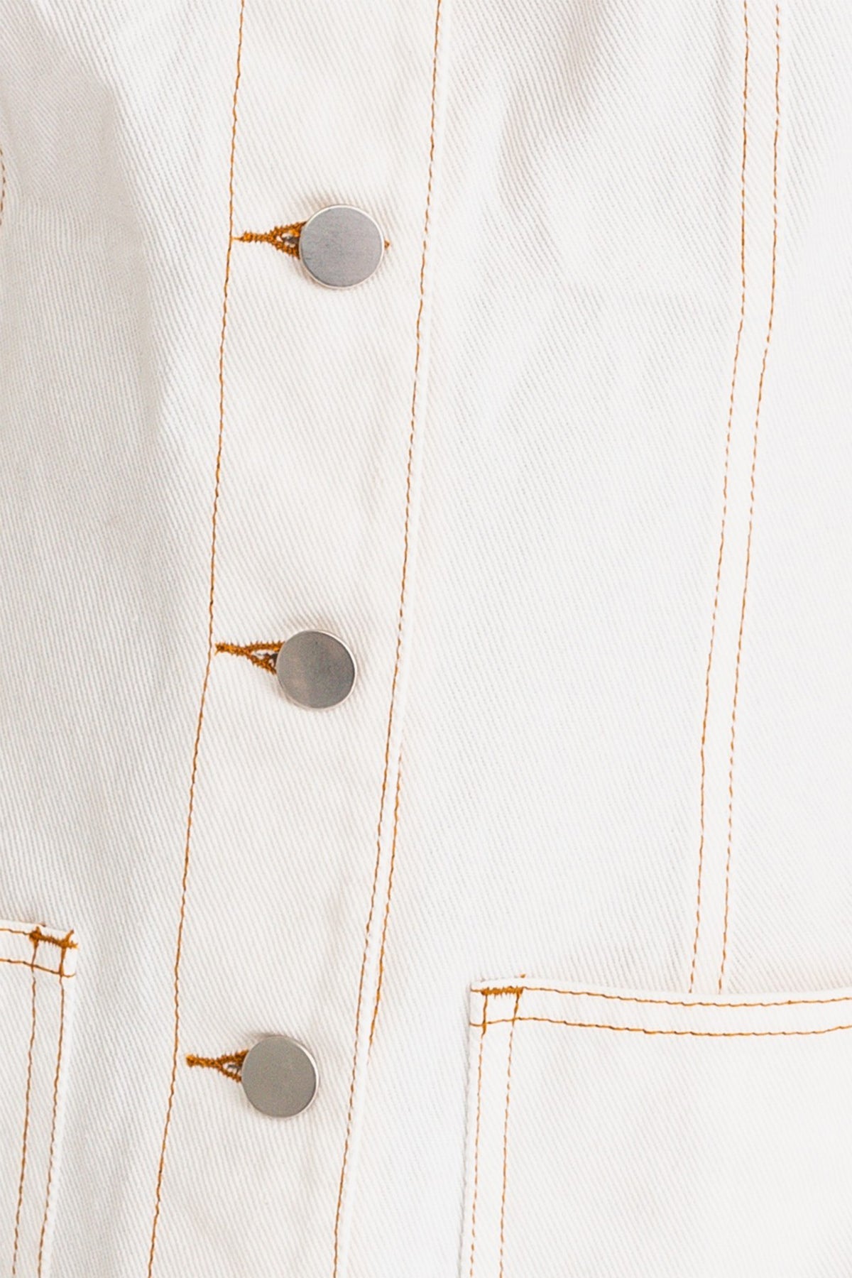 Closeup image of a model wearing a trendy white mini denim dress from Boho Bum Island Boutique.