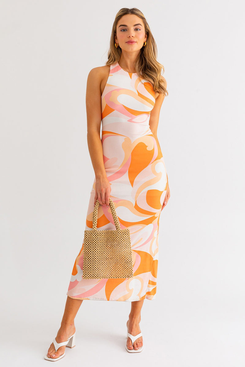 Model wearing a halter neck cross back midi summer dress in orange and white multicolor from Boho Bum Island Boutique