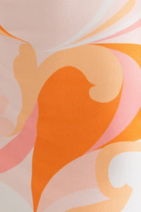 Swatch of a model wearing a halter neck cross back midi summer dress in orange and white multicolor from Boho Bum Island Boutique