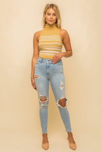 Model wearing a yellow & white striped turtle neck tank top from Boho Bum Island Boutique