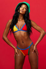 Model wearing a bikini set in red, green, blue and yellow from Boho Bum Island Boutique by Beach Riot